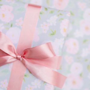 a present wrapped in pink ribbon with a pink bow